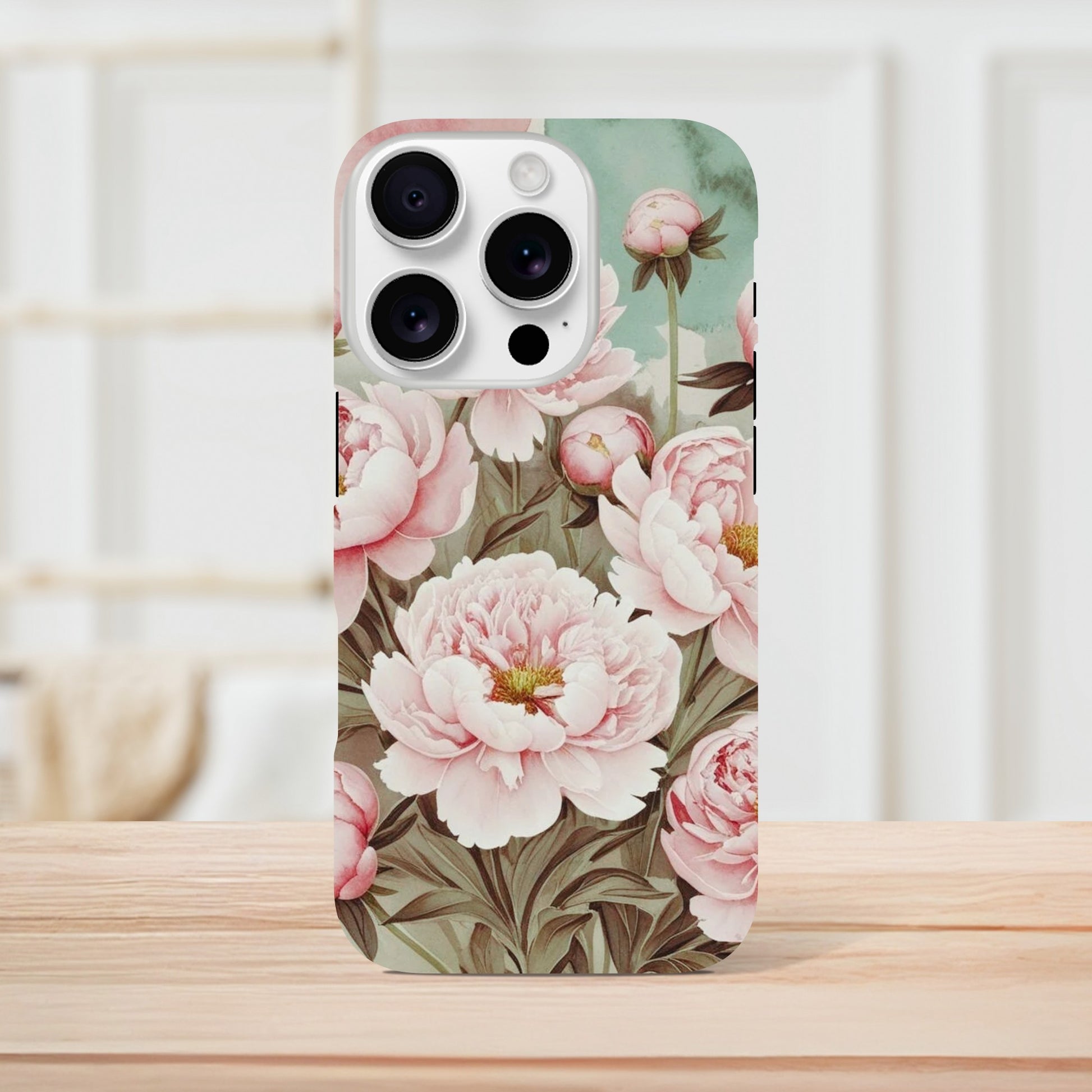 Protect your iPhone in style with a dual-layer tough case featuring pink peonies on a mint green background. Fits iPhone 12+ and supports wireless charging.