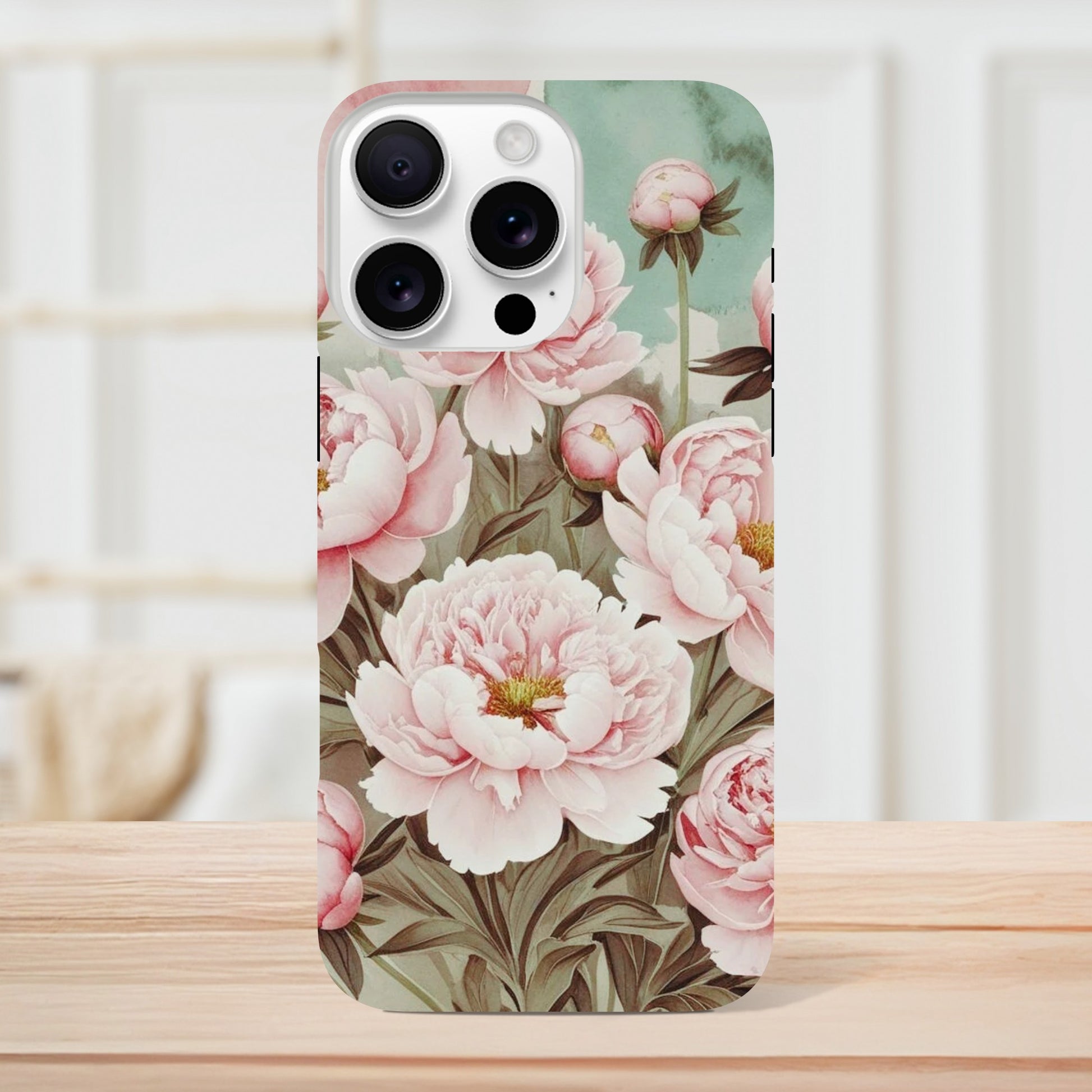 Protect your iPhone in style with a dual-layer tough case featuring pink peonies on a mint green background. Fits iPhone 12+ and supports wireless charging.