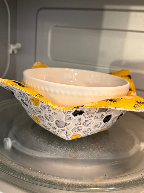 Hand-sewn bowl cozies made of 100% cotton, washable, and designed to protect hands from heat and cold. Fits most medium soup bowls.